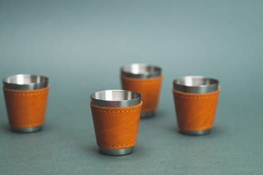 Metallic shot glasses. travel shot glass for alcohol with leather casing over the stainless steel. personal accessory set