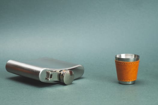 Stainless steel flask with shot glass. travel shot glass for alcohol with leather casing over the metal. personal accessory set. copy space