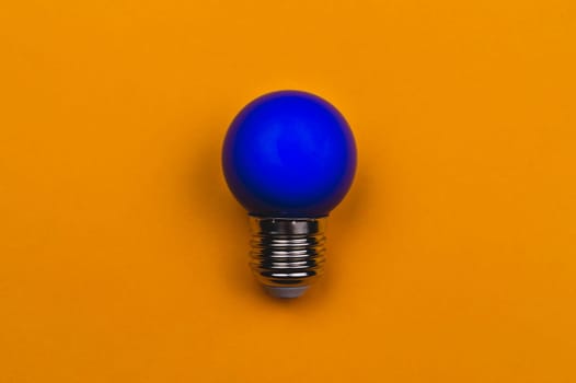 Blue light bulb on a yellow background. single bulb with copy space