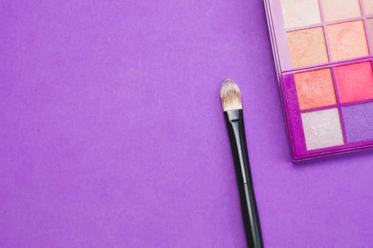 Makeup brushes with powder on purple background. various cosmetic brushes close up. skin care accessories