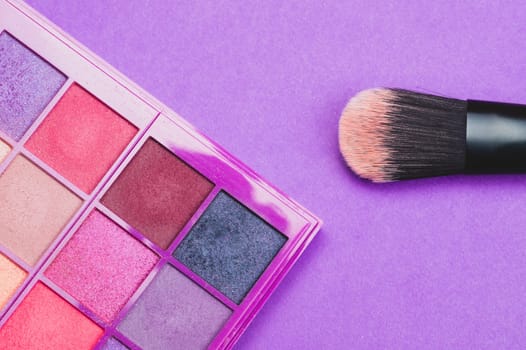 Makeup brushes with powder on purple background. various cosmetic brushes close up. skin care accessories