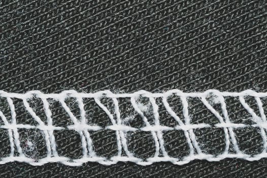 White seams on black fabric. stitches on textile material close up