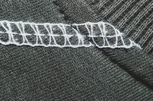 White seams on black fabric. stitches on textile material close up