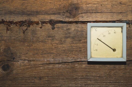 Vintage thermometer hanging on a wooden wall. celsius scale with degrees. indoor temperature measurement