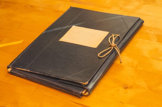 Vintage folder for paper with blank label. old folder for documents lies on a wooden table. copy space