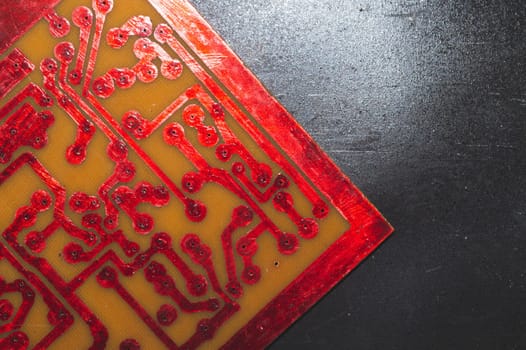 Handmade circuit board with red soldered tracks. industrial background. textolite with soldering