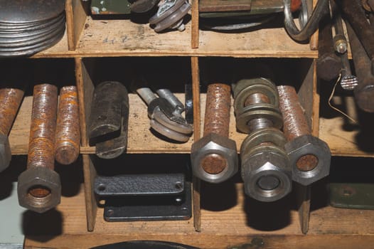 Metal bolts and nuts in the work shelf. various fasteners. rusty details in workshop