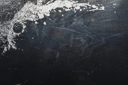 Black steel plate with white paint spots. metal surface with paint splashes. grunge texture. iron background