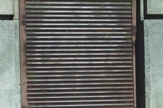 Iron window blind. rusty metal roller shutter. metal curtain close up