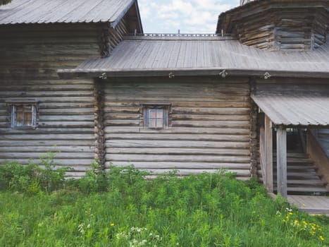 Facade of old wooden house. small windows. traditional architecture. entrance with porch