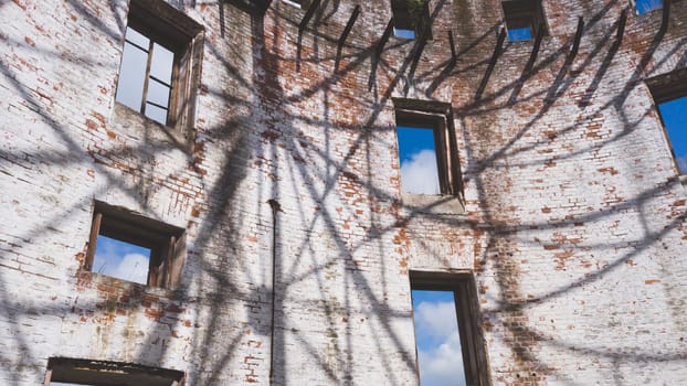 Curved brick wall of ruined building. sky is visible through the windows. part of destroyed house. old architecture