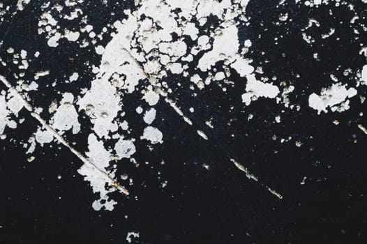 Black steel plate with white paint spots. metal surface with paint splashes. grunge texture. iron background