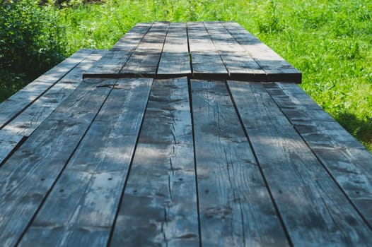 Wooden table in the park. summer day. green foliage on the background