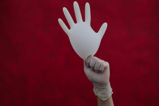 Hand holds inflated protective glove on a red background