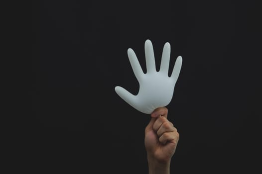 Hand holds inflated protective glove on a black background
