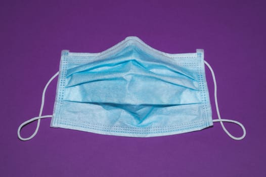 Medical mask on violet background. preventive measures against coronavirus and respiratory illness
