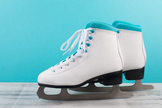 Pair of ice skaters in front of a blue background, shoes for women