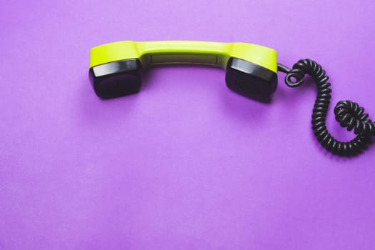 Vintage green telephone handset. phone receiver isolated on purple background. old communication technology. copy space