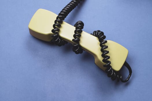 Vintage green telephone handset. phone receiver isolated on blue background. old communication technology. copy space