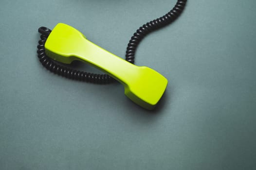Vintage green telephone handset. phone receiver isolated on color background. old communication technology. copy space