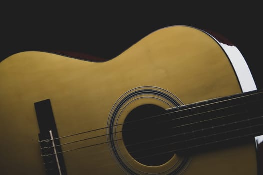Guitar on the black background. acoustic musical instrument