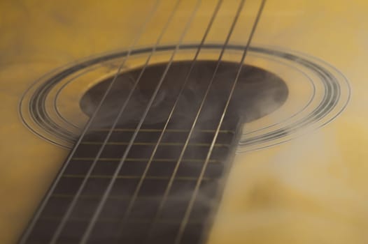Guitar in smoke close up. acoustic musical instrument. strings on the guitar neck