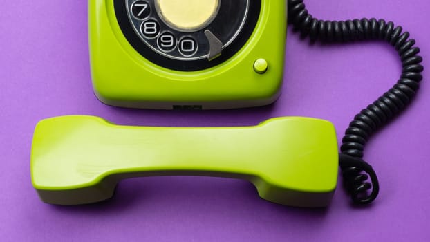 Classic phone with handset. vintage green telephone with phone receiver isolated on purple background. old communication technology. copy space