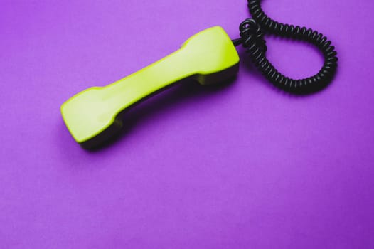 Vintage green telephone handset. phone receiver isolated on purple background. old communication technology. copy space