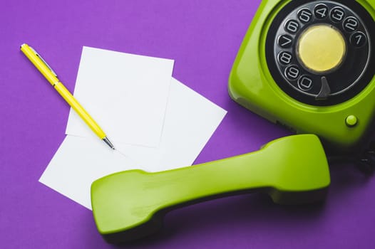 Classic phone with handset. pen with a note. office background. vintage green telephone with phone receiver. old communication technology. copy space
