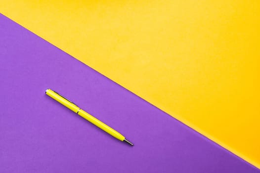 Yellow pen on color background