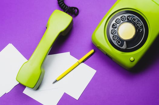 Classic phone with handset. pen with a note. office background. vintage green telephone with phone receiver. old communication technology. copy space
