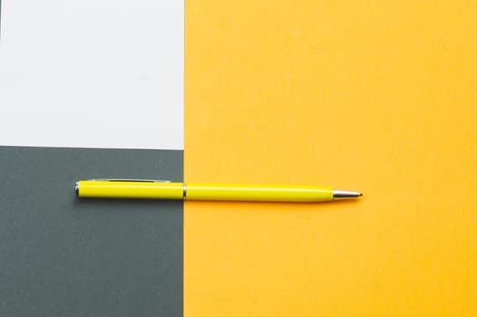 Yellow pen and white note on colored background
