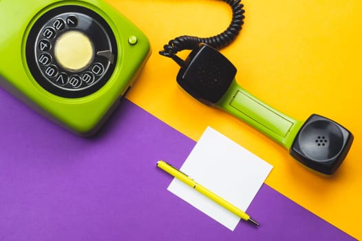Classic phone with handset. pen with a note. office background. vintage green telephone with phone receiver. old communication technology. copy space