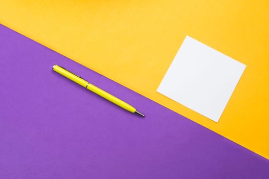 Yellow pen and white note on colored background