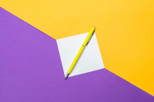 Yellow pen and white note on colored background