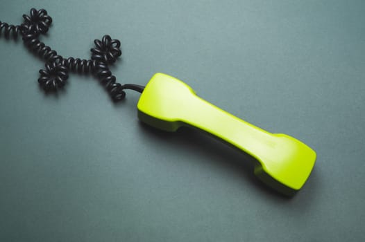 Vintage green telephone handset. phone receiver isolated on color background. old communication technology. copy space