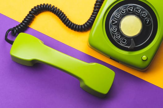 Classic phone with handset. vintage green telephone with phone receiver on color background. old communication technology. copy space