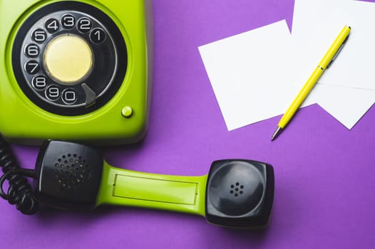 Classic phone with handset. pen with a note. office background. vintage green telephone with phone receiver. old communication technology. copy space