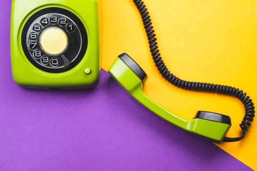 Classic phone with handset. vintage green telephone with phone receiver on color background. old communication technology. copy space