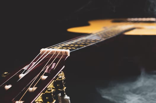 Guitar in smoke close up. acoustic musical instrument. strings on the guitar neck