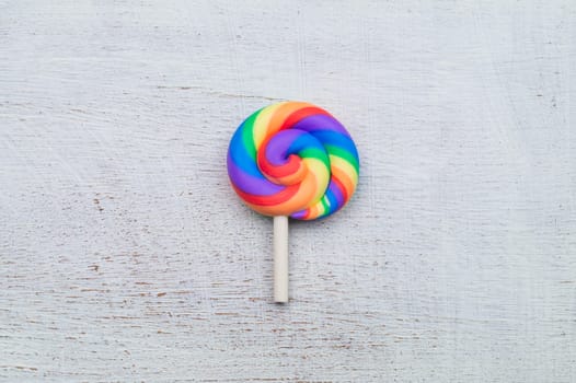 Lollipop on white wooden background. colorful candy close up. copy space