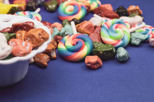 Lollipops and candy pebbles. sweets in the form of colored stones. colored background with colorful candies. copy space