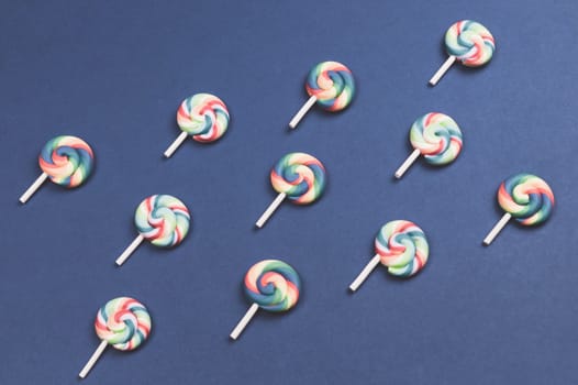 Lollipops are arranged symmetrically on a colored background. colorful candies. pattern of sweets