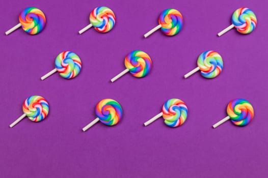 Lollipops are arranged symmetrically on a colored background. colorful candies. pattern of sweets