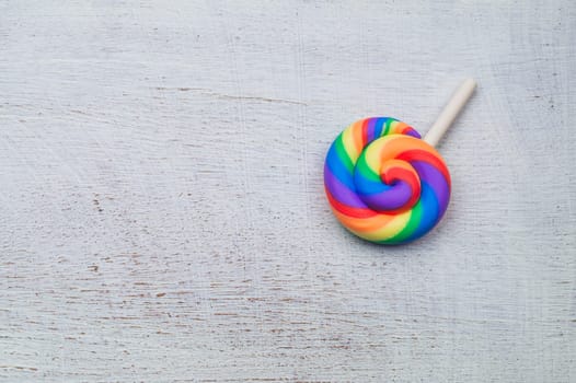 Lollipop on white wooden background. colorful candy close up. copy space