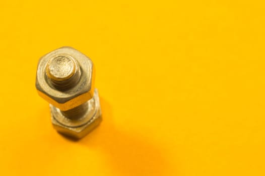 Steel screw on a yellow background. working tools