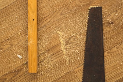 Old hand saw on a wooden background. working area with hand tool. carpentry instrument. manual labor concept