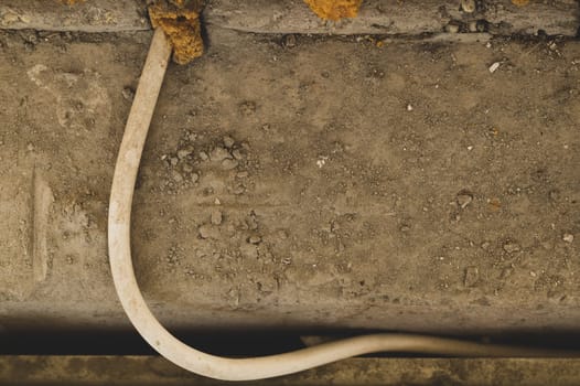 White cable sticking out of the wall. cabling process. industrial grey stone background
