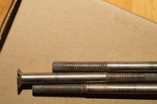 Screws on a cardboard background. work tool