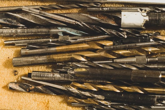 Different drills in a box. pile of drill bits in a case. working tools